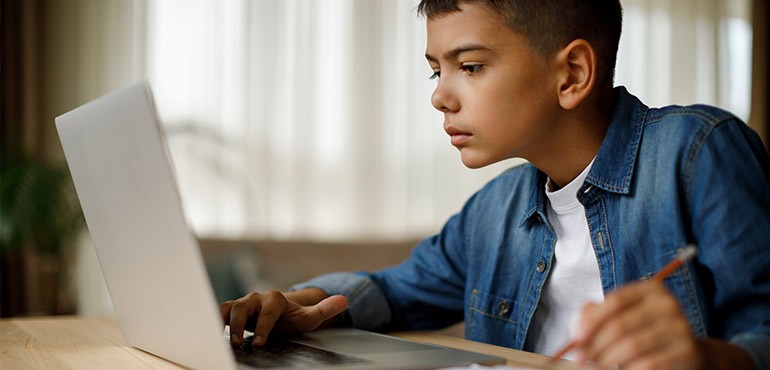 Digital_primary A young boy looks intently at his laptop.